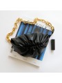Bolso pouch negro con cadena bandolera en cuero suave, cierre de marco metálico forrado en cuero, acabado dorado.