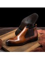 Brown Chelsea boots in cowhide leather with brogue details, side elastics, and back pull tab.