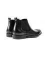 Black Chelsea boots in cowhide leather with brogue details, side elastics, and back pull tab.