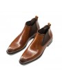 Brown Chelsea boots in cowhide leather with brogue details, side elastics, and back pull tab.