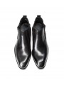 Black Chelsea boots in cowhide leather with brogue details, side elastics, and back pull tab.