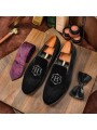 Black velvet slippers with embroidery detail, round toe, and refined finishes.