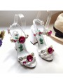 Sandalias blancas con correas, tacones altos y broches, con plantilla de cuero.