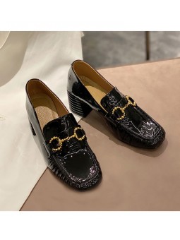 Black patent leather loafers with a mid heel and metal bit detail. Leather insole and rubber outsole for maximum comfort