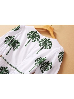 White flowing dress with palm tree pattern