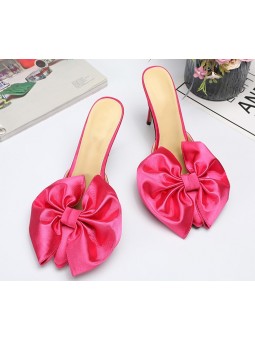 Sandali rosa con tacchi a spillo e un raffinato fiocco. Eleganza e femminilità ad ogni passo.