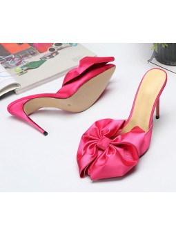 Sandali rosa con tacchi a spillo e un raffinato fiocco. Eleganza e femminilità ad ogni passo.