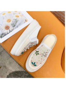 Elegant white flat shoes with rhinestones, side elastics, and a rubber sole.