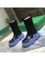 Black patent leather Chelsea boots with a blue lugged sole. A bold and modern style!
