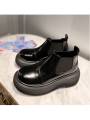 Short black Chelsea boots with black sole in patent leather