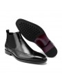 Stivaletti Chelsea in pelle nera con dettagli brogue, elastici laterali, punta dritta e tacco.