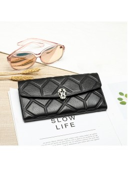 Black quilted-effect grained leather long wallet with flap and snakehead clasp. Two compartments with card slots.