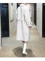 Abrigo de lana blanco con doble botonadura, cinturón de hebilla y cierre con botones. Atemporal y sofisticado.