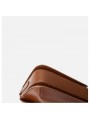 Sac à bandoulière style minimaliste en cuir marron avec rabat et fermeture à bouton pression.