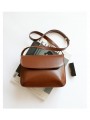Minimalist-style brown leather shoulder bag with flap and snap button closure.