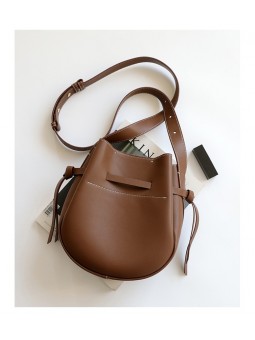 Borsa a secchiello in pelle marrone con chiusura a cinturini e tracolla in pelle, cuciture a vista.
