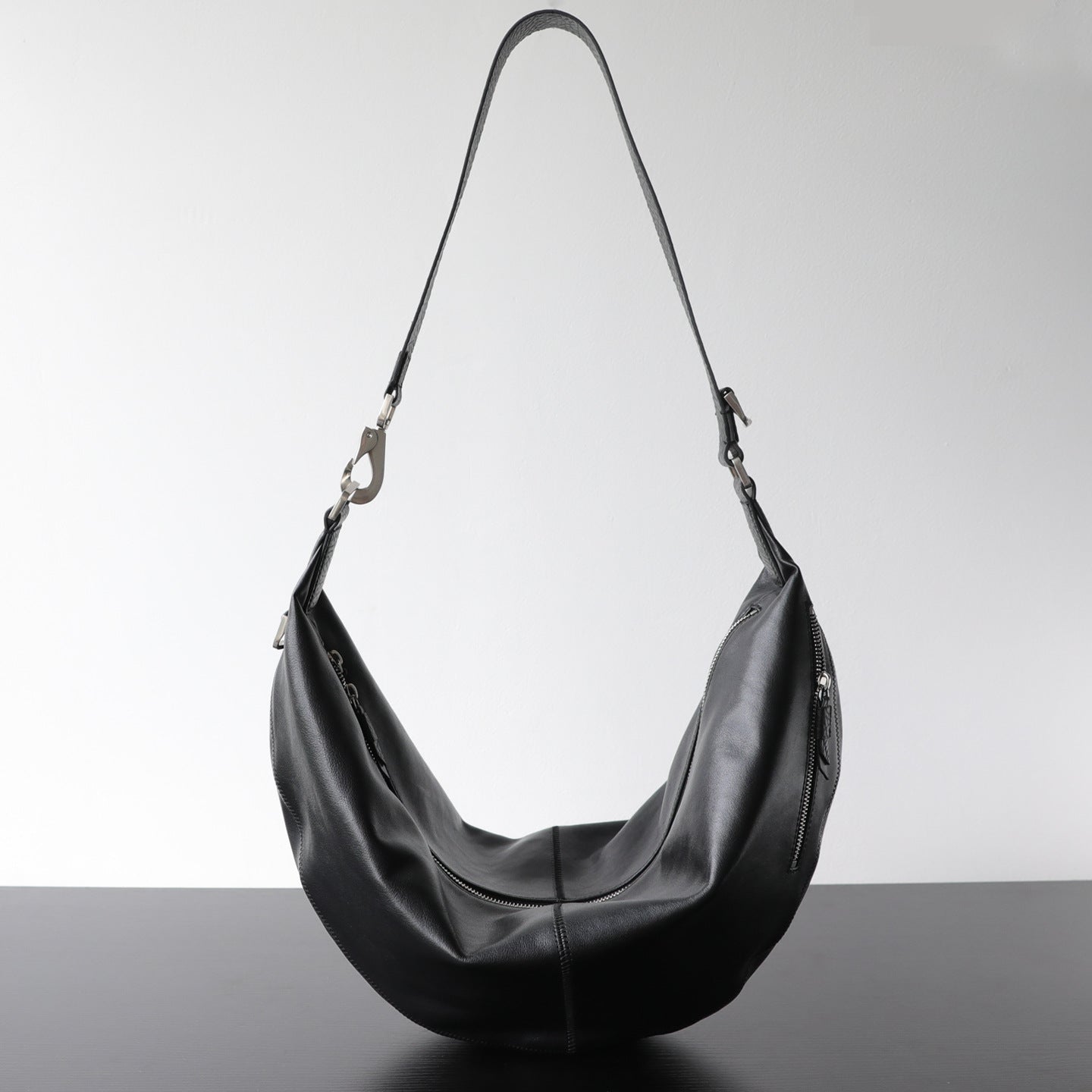 Sac croissant femme en cuir véritable, sac bandoulière noir – vue de face.